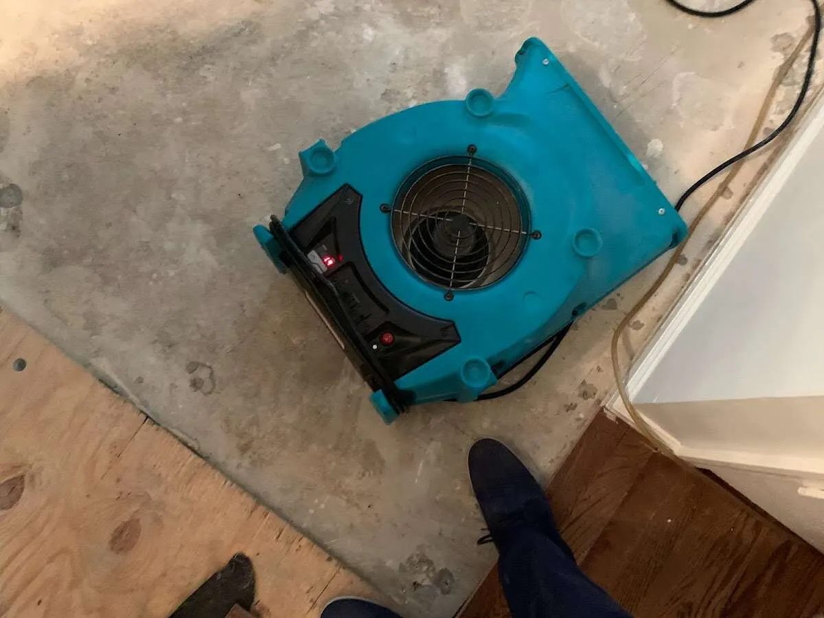 Air mover drying subfloor during Commercial Water Damage Restoration in Bolivar